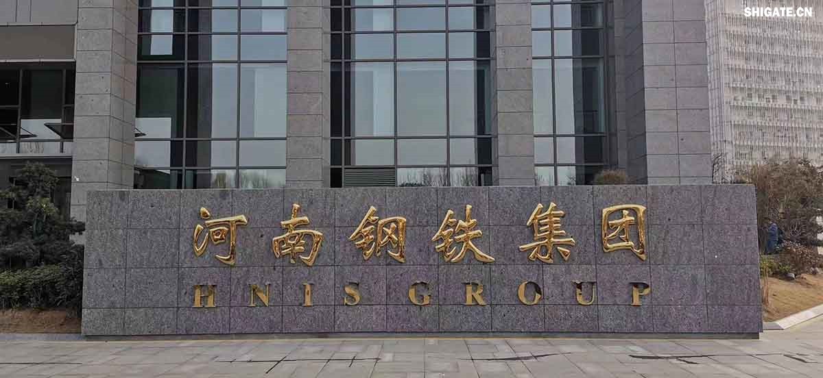 6月1日，河南鋼鐵集團周口基地簡稱（周鋼）二期寬厚板項目控制中心迎來重要里程碑：當操作員按下5500mm精軋機的軋制按鈕，通紅的鋼板如熔金般奔騰穿過軋輥，標志著5500mm軋機熱試圓滿成功。這一震撼場景與5月31日RH真空精煉爐、熱處理線熱試成功交相輝映，正式宣告世界首條“5600mm+5500mm雙超寬機架”寬厚板生產(chǎn)線全線貫通！生產(chǎn)線總長度達到1.4公里，構成了國內(nèi)已知更長的寬厚板軋鋼車間，連接了近20個精密工序，深基坑群實現(xiàn)了全線的貫通布局。至此，河南鋼鐵集團強勢躋身全球鋼鐵制造“一梯隊”，其智能化、綠色化發(fā)展及特鋼轉(zhuǎn)型進程由此開啟全新篇章！